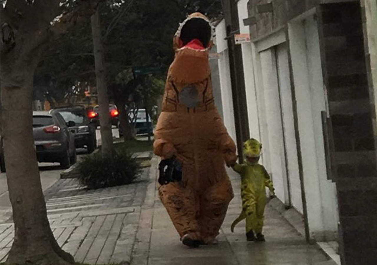 Papá lleva a la escuela a su pequeño con disfraz de dinosaurio