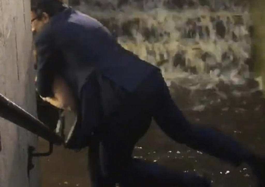 Mujer carga a señor para no mojar su traje en inundación
