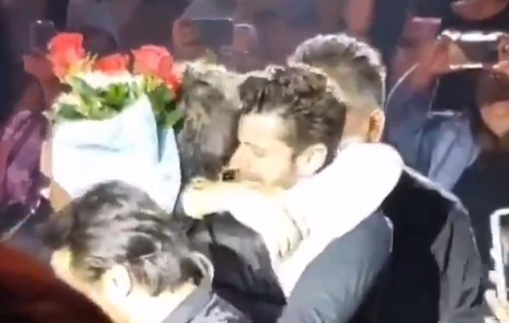 Alejandro Fernández recibe rosas de un hombre durante palenque