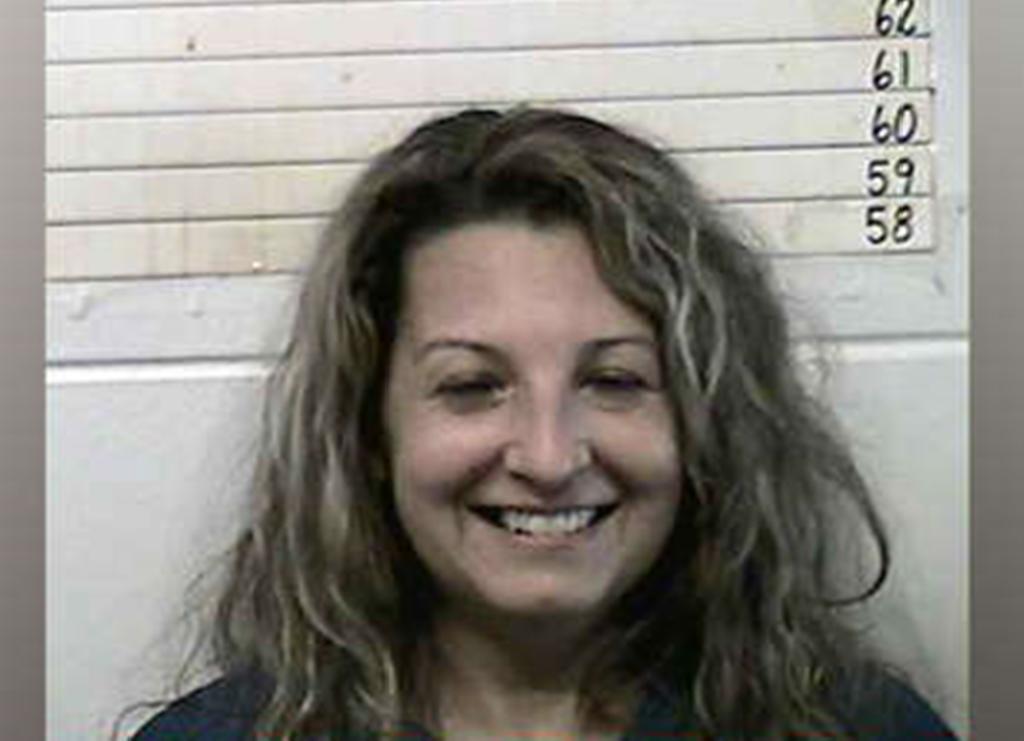 Mujer sonríe al ser arrestada por matar a su marido