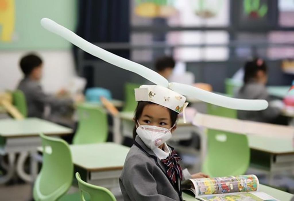 Niños en China regresan a la escuela con ‘sombreros de distanciamiento social’