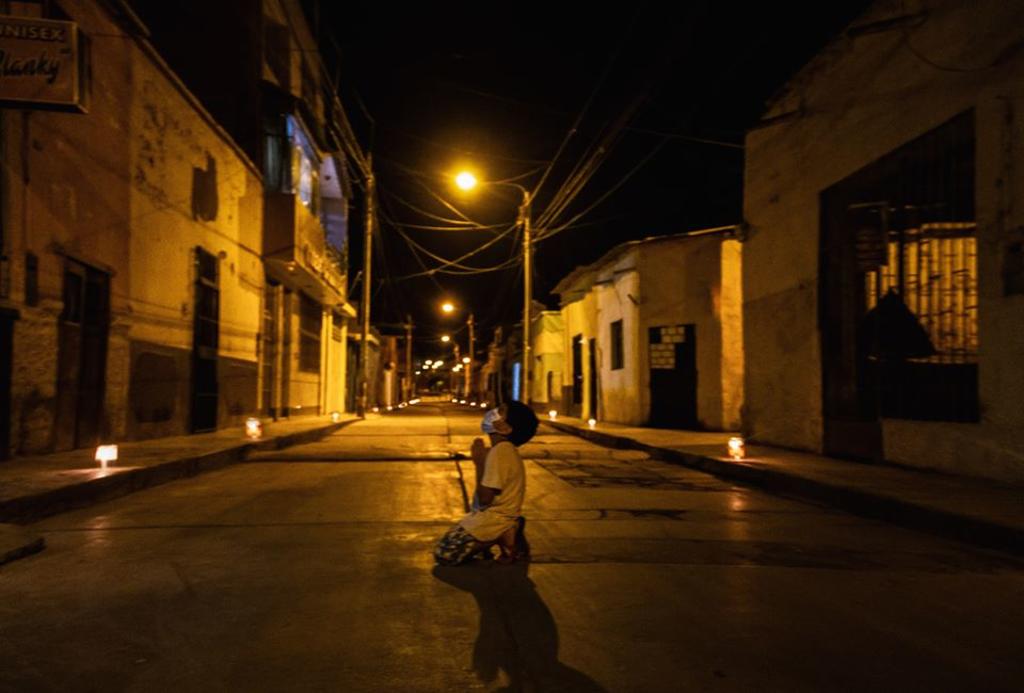 Niño reza arrodillado en la calle para que termine la pandemia de COVID-19