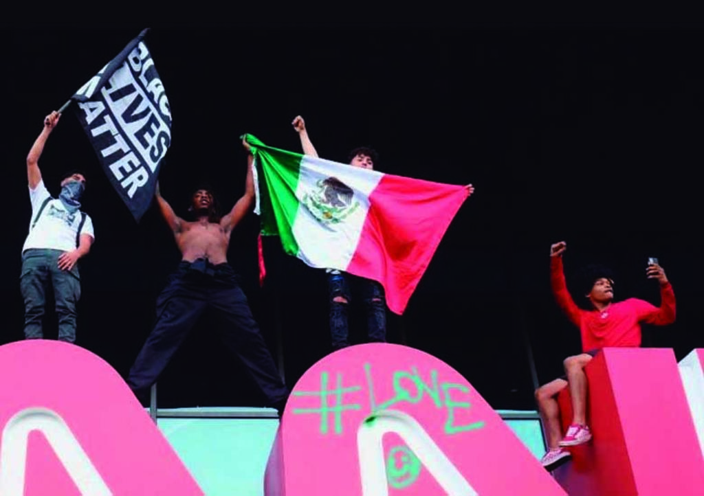 Alzan la bandera de México durante protestas en EUA; dos causas se unen