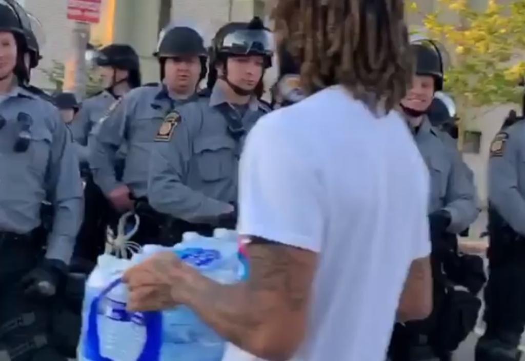 VIDEO: Joven reparte agua a policías durante manifestaciones en EUA