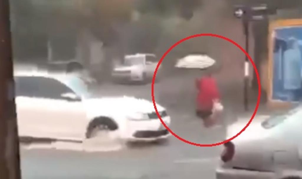VIRAL: Mujer 'desaparece' bajo la lluvia mientras caminaba en la calle