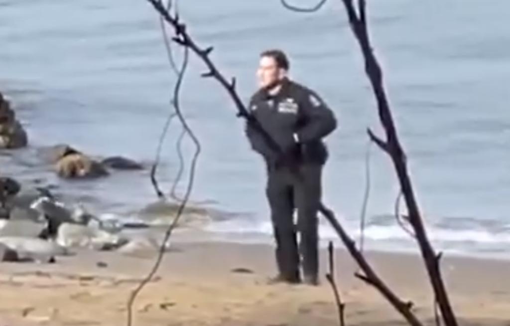 Captan a policías tomándose fotos con un cadáver en la playa