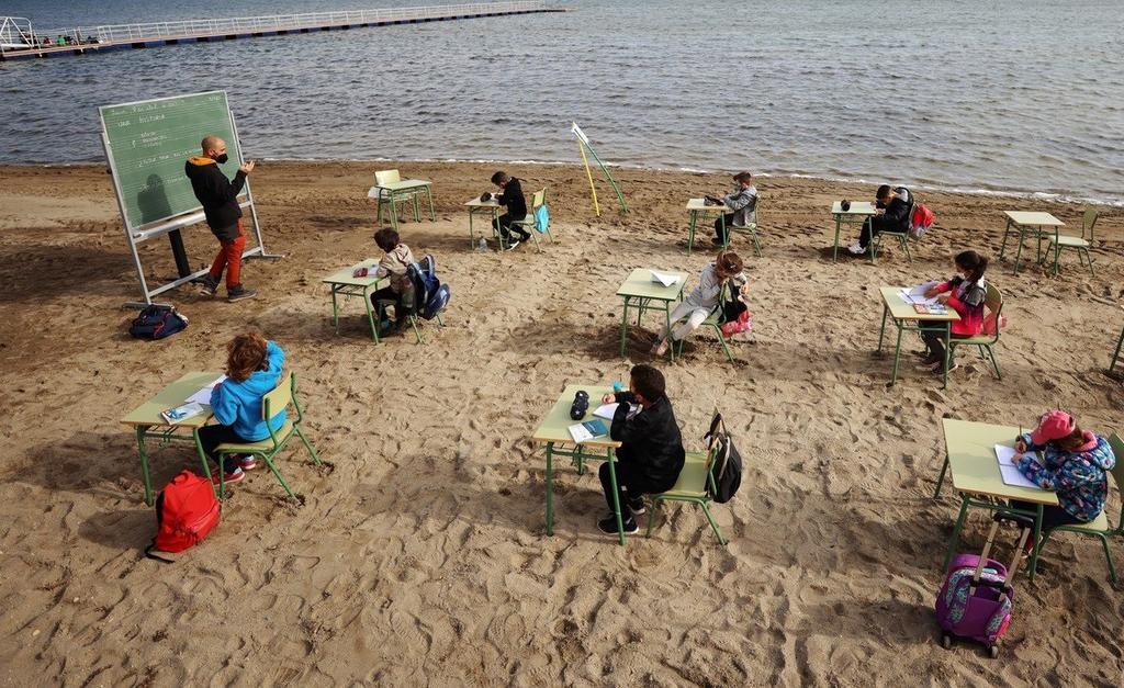 Niños en España toman clases presenciales frente al mar