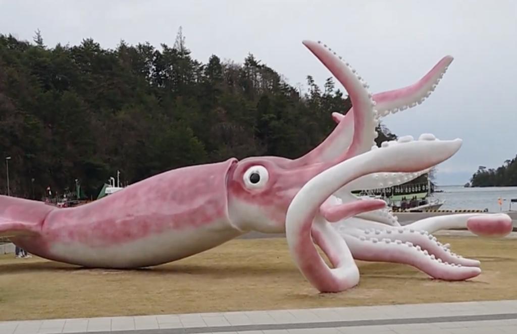 Japoneses usan dinero para combatir la pandemia, en una estatua de calamar gigante