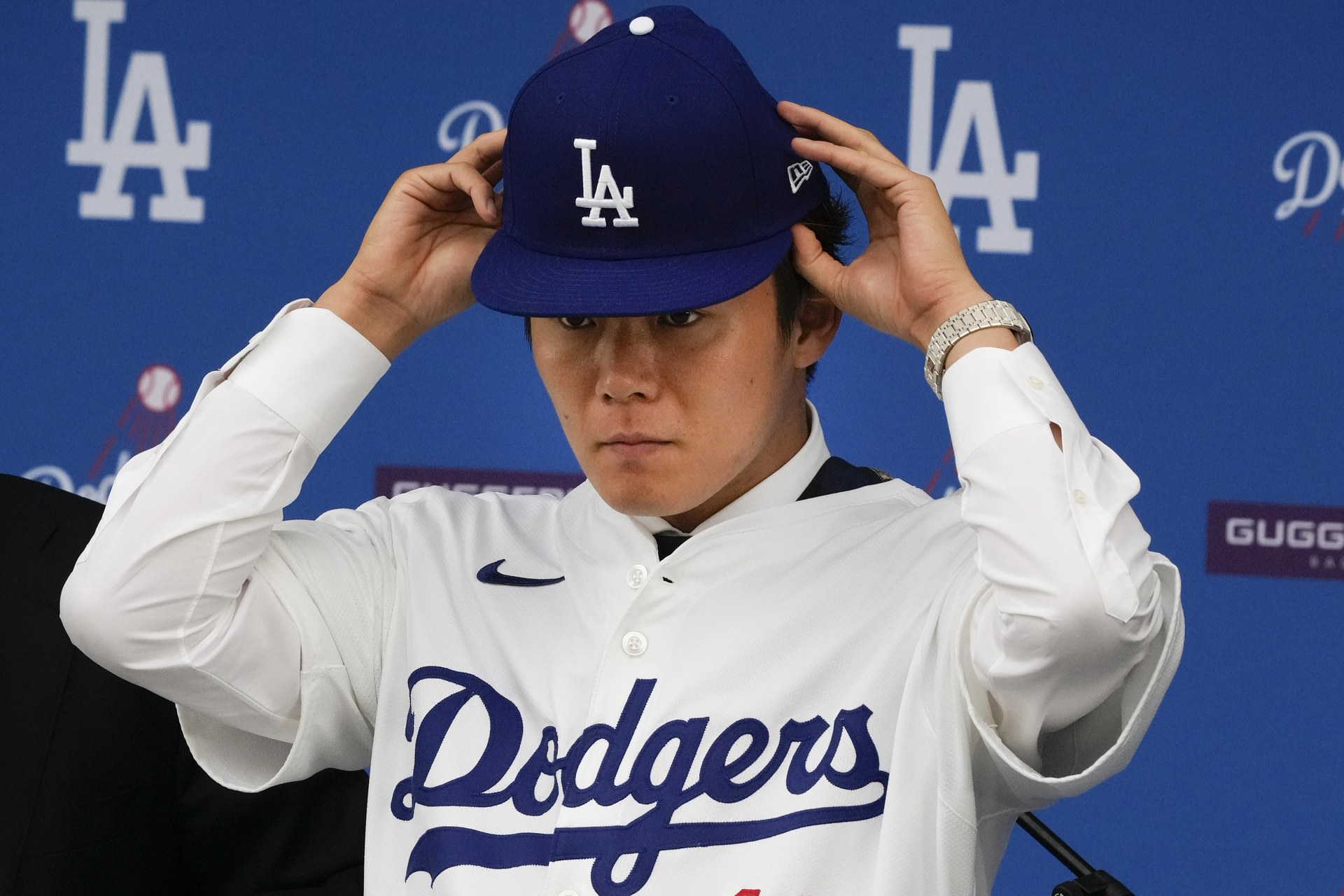 Yoshinobu Yamamoto se coloca la gorra durante la conferencia en que fue presentado como nuevo jugador de los Dodgers de Los Ángeles, el miércoles 27 de diciembre de 2023 (AP Foto/Damian Dovarganes)


