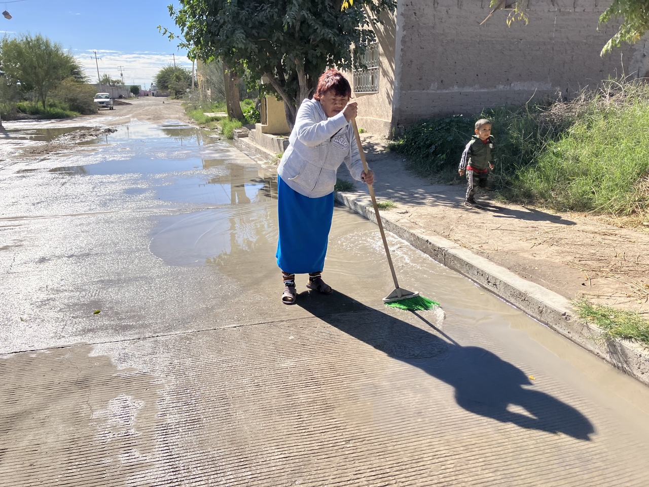Todos los días, la señora Esperanza barre el agua del drenaje que se acumula al frente de su casa.